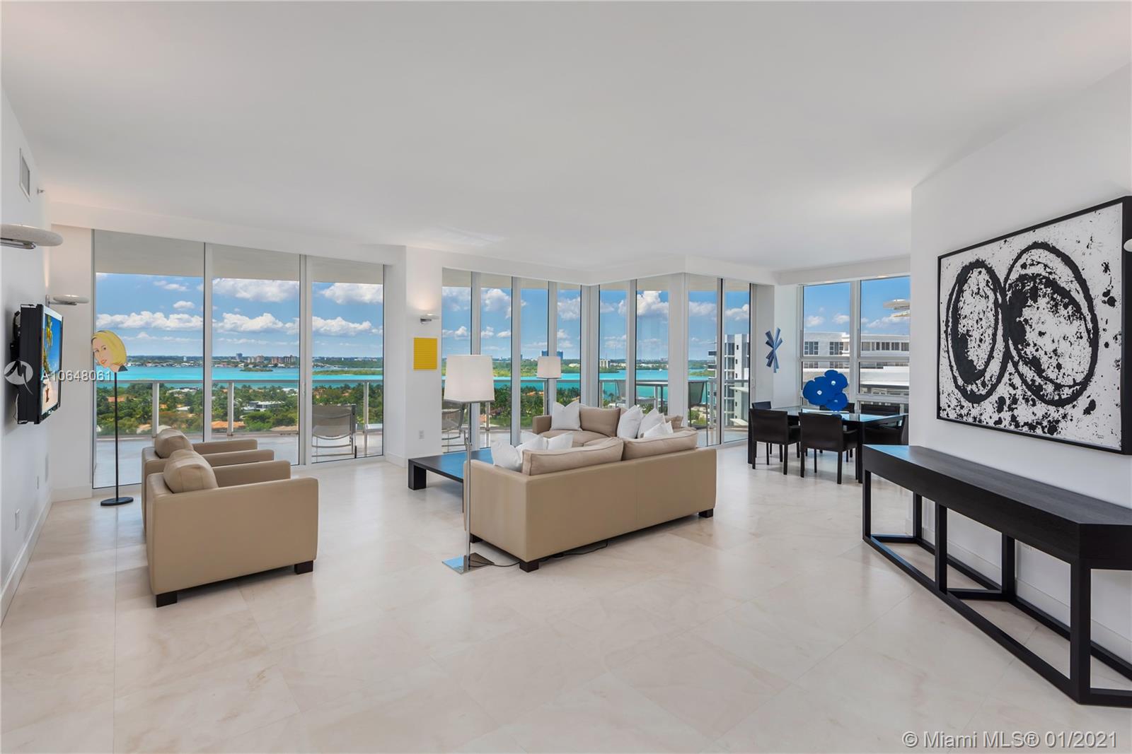 Grand living room and dining area with views of the Intracoastal Waterway, Haulover Sandbar and city.