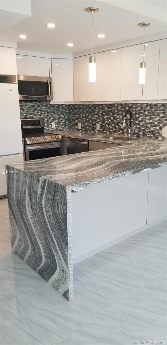 Quartz countertop with waterfall. led faucet and glasss mosaic backsplash  brand new appliances