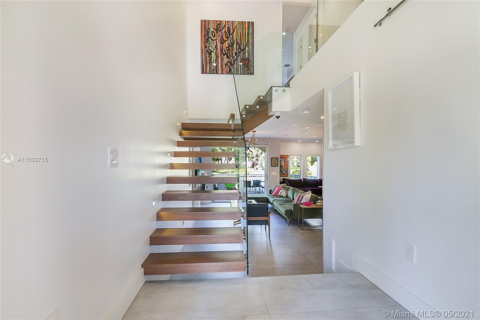 Upon entering the residence, this ethereal staircase features cantilevered glass with black walnut floating steps with a modern open floor plan.