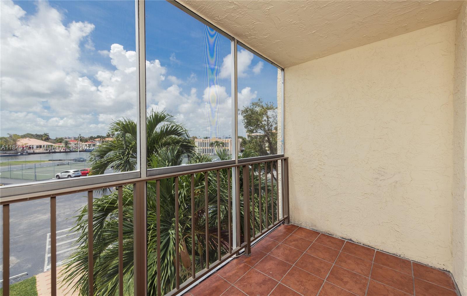 Photo of 701 Three Islands Blvd  #315, Hallandale Beach, Florida, 33009 - WATER & TENNIS COURT VIEW FROM SCREENED BALCONY
