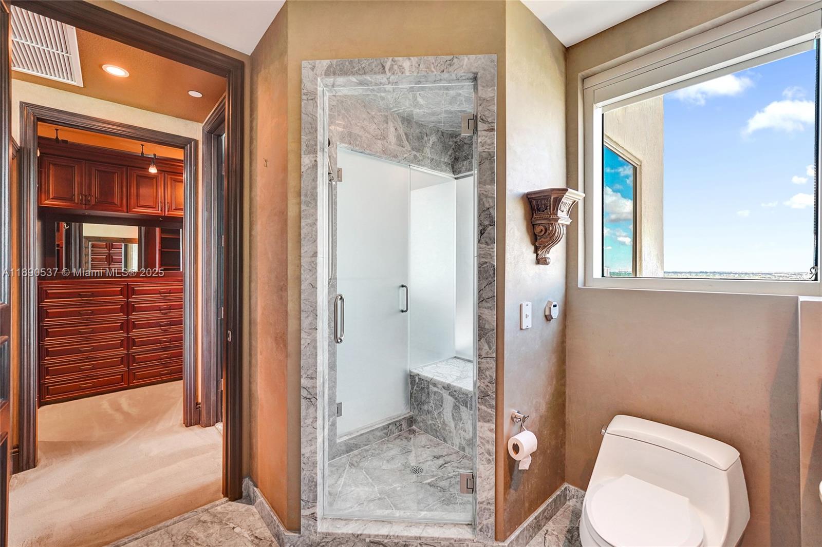 Photo of 16047 Collins Ave  #2101, Sunny Isles Beach, Florida, 33160 - Bathroom with steam shower directly across from the bedroom.....window with the natural light!  Peek through the window at the city and water views too!