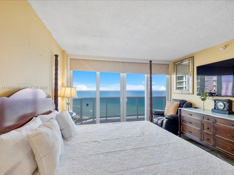 Photo of 16711 Collins Ave  #1604, Sunny Isles Beach, Florida, 33160 - Primary bedroom with door to balcony and ocea views
