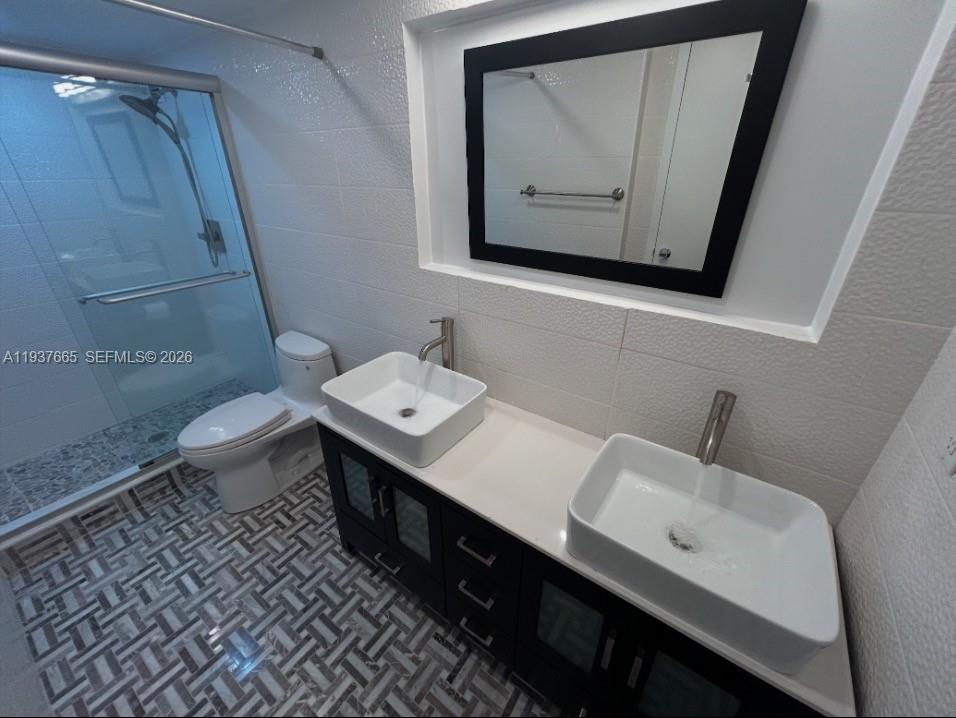 Photo of 2030 Ocean Dr  #506, Hallandale Beach, Florida, 33009 - second bathroom double sinks with marble mosaic floors. and tile walls