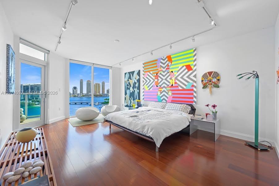 Photo of 3201 183 #1104, Aventura, Florida, 33160 - Partial view of the ample Primary Bedroom with lovely wood floors. Note: the beautiful window overlooking the water, and the intrcoastal views.