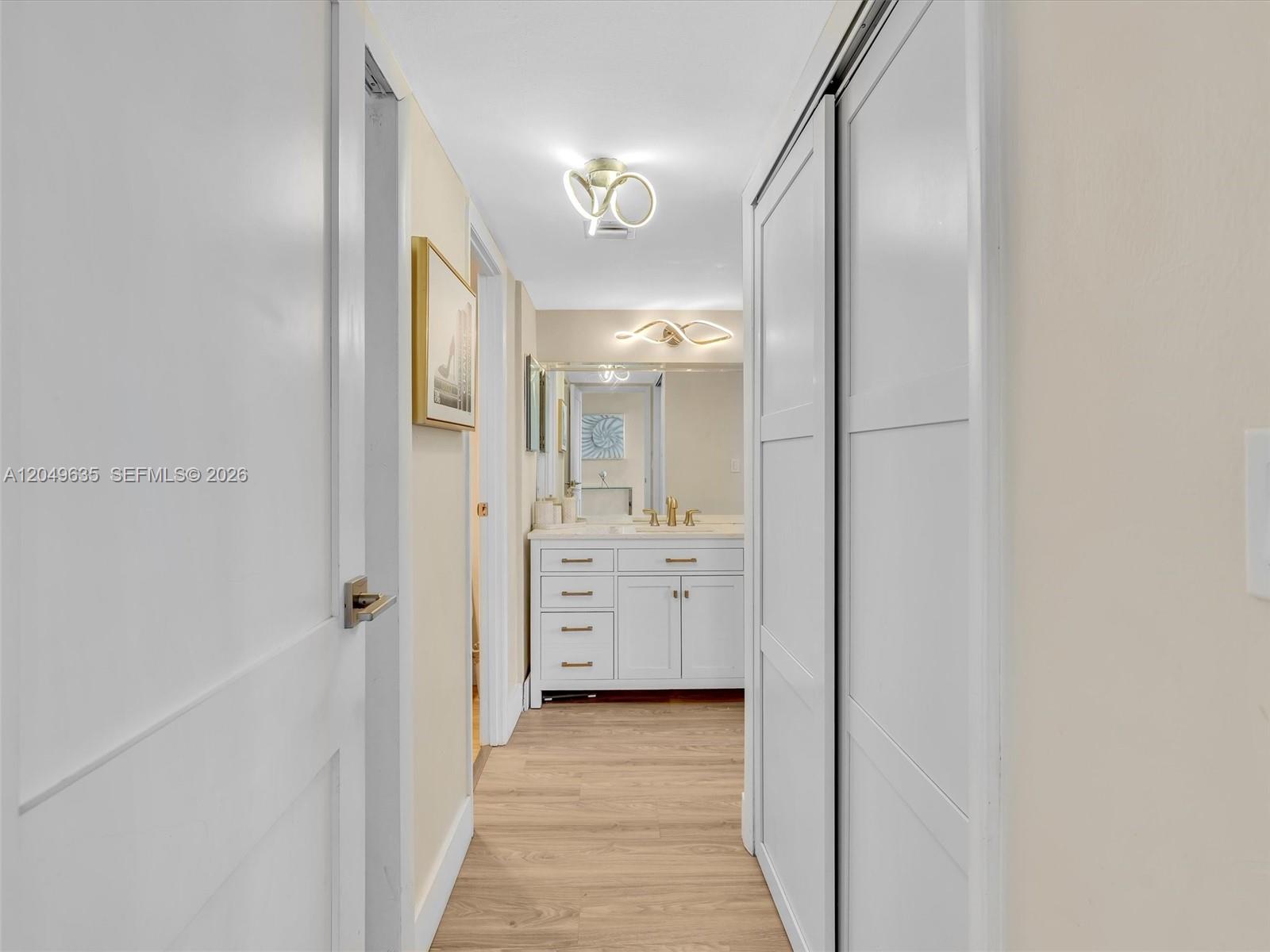 Photo of 20301 Country Club Dr #622, Aventura, Florida, 33180 - Hallway leading to the primary suite with custom built-in closets and private bathroom