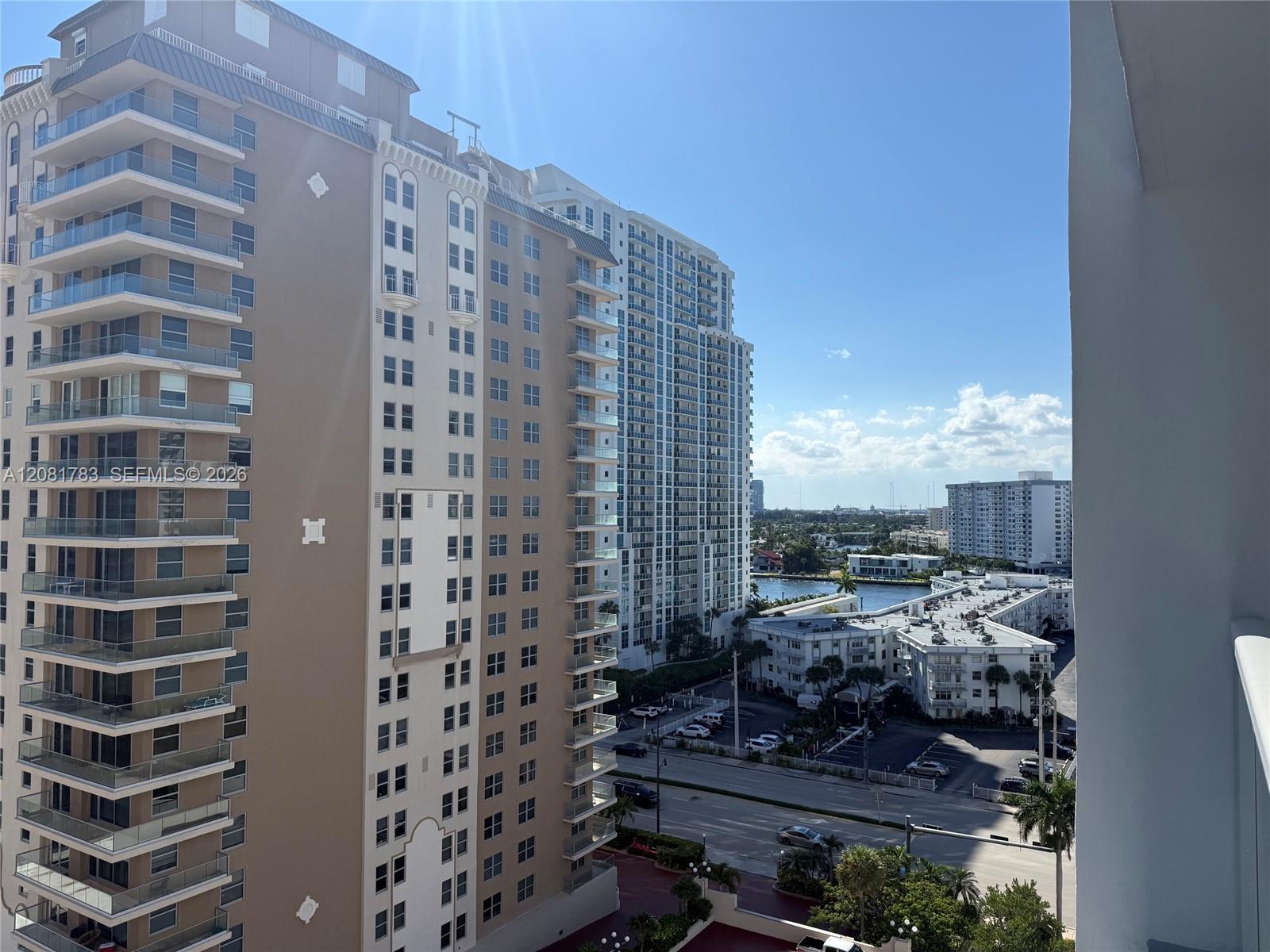 High-rise residential building featuring stacked private balconies with glass railings and urban exterior facade