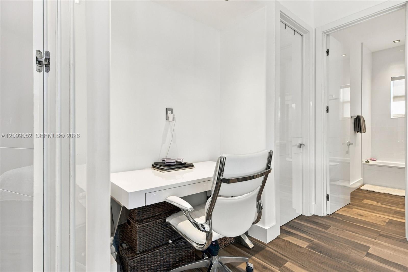 Built-in white desk with drawer storage, recessed lighting, and wood-finish flooring