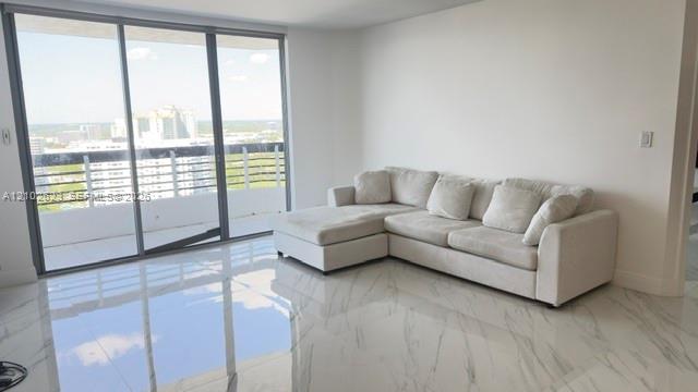 Large-format polished tile flooring, floor-to-ceiling glass sliding doors, and balcony access