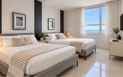 Expansive window offering ocean scenery, bright white walls, dark accent wall, and polished tile flooring