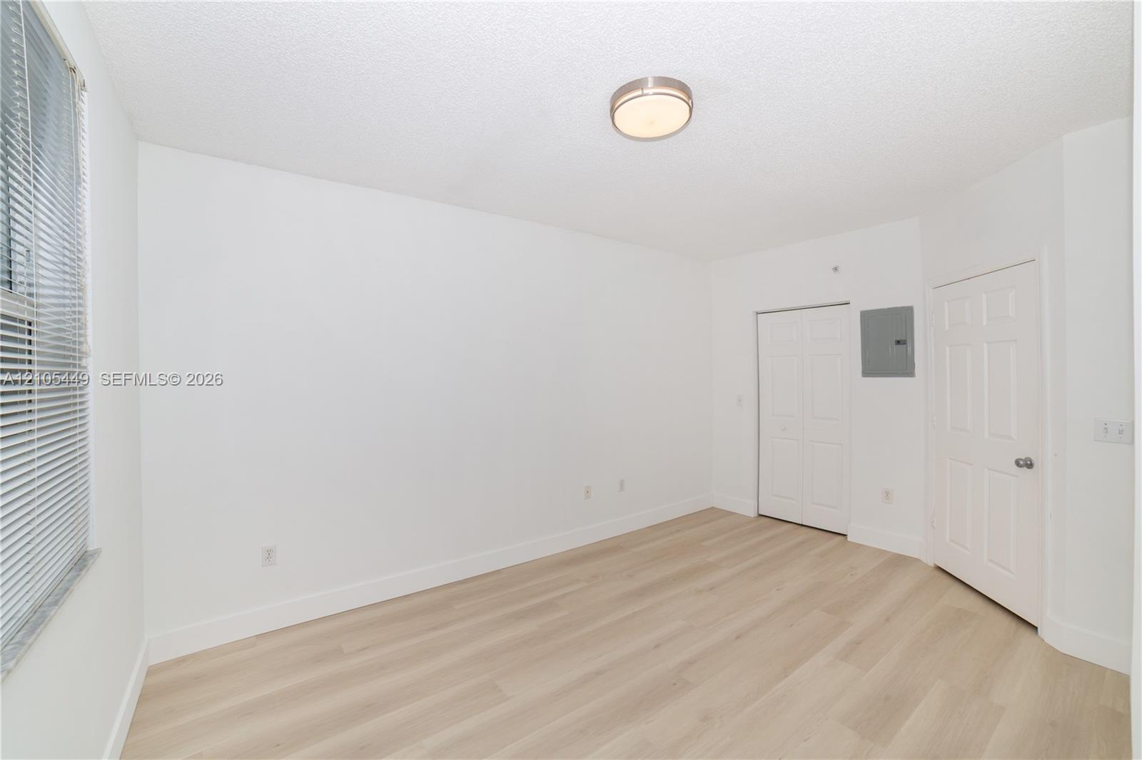 Light wood-finish flooring with white baseboards