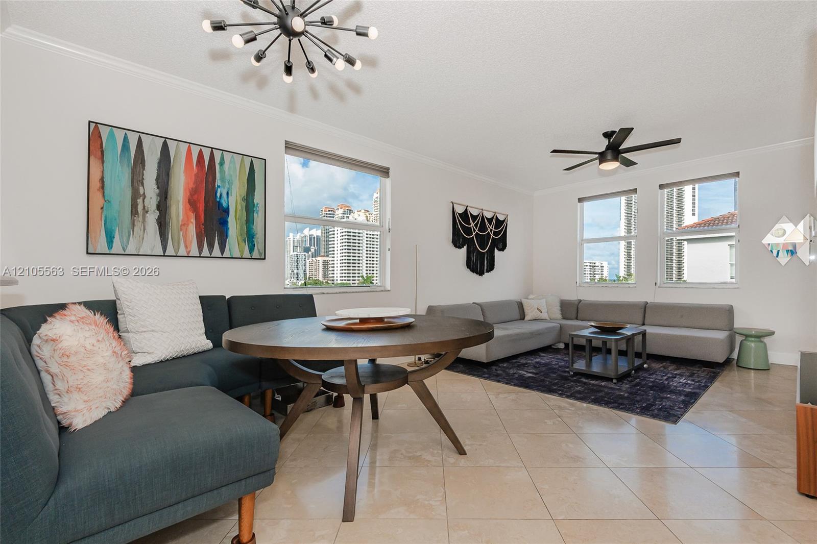 High ceilings with crown molding, ceiling-mounted fan, multiple windows, and tile flooring
