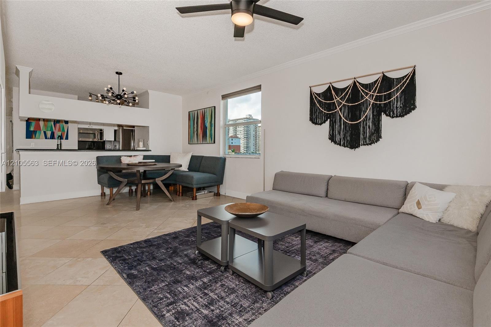 Open-concept living area with tile flooring and a ceiling fan