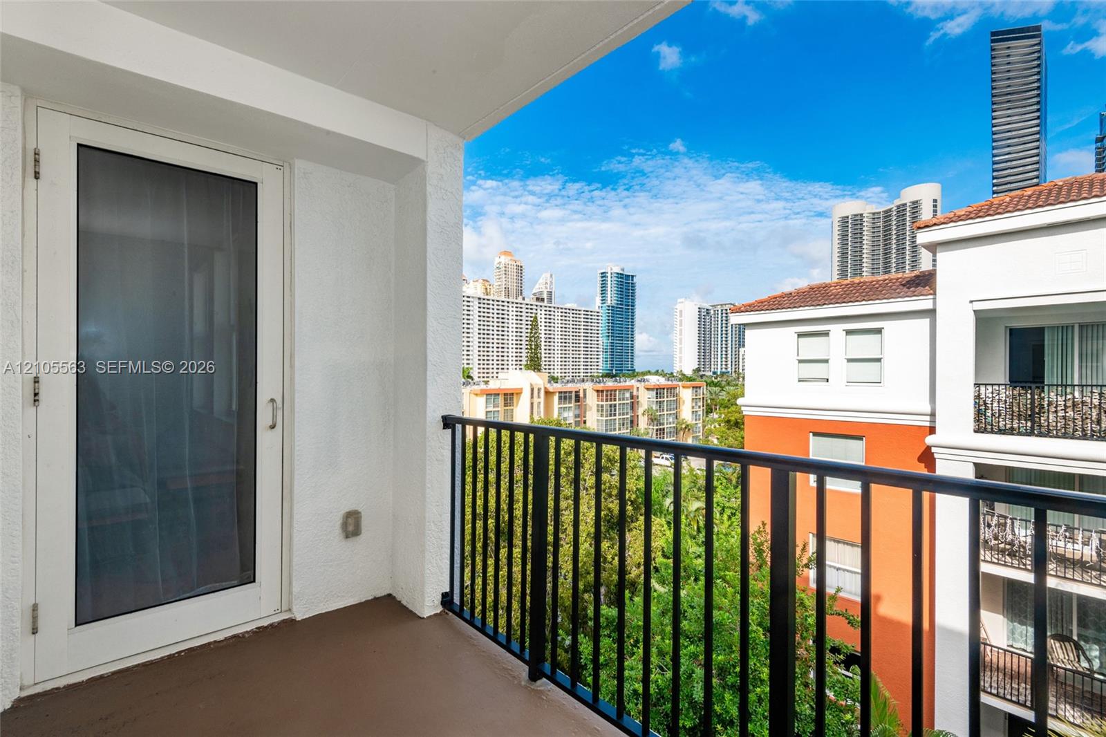 Private balcony with a metal railing, featuring a glass-paneled door