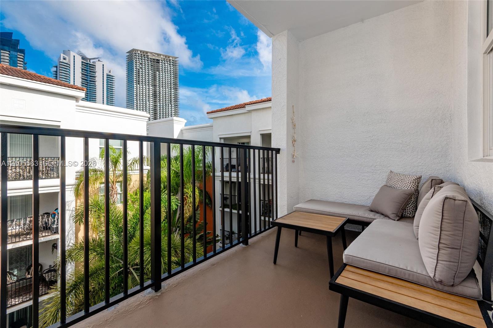 Private balcony featuring a textured wall finish and a black metal railing