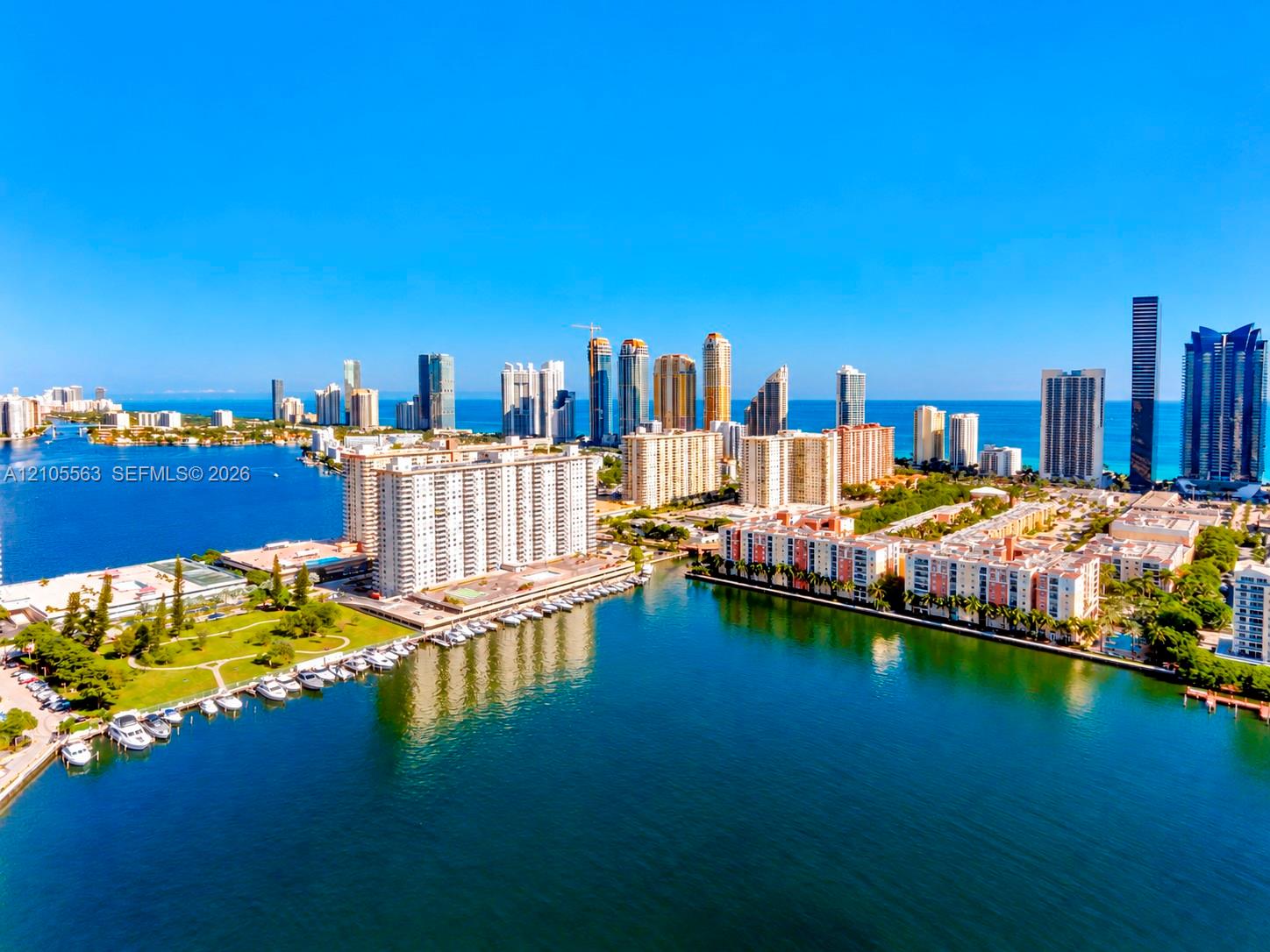 Waterfront property featuring marina access, a city skyline, and ocean proximity