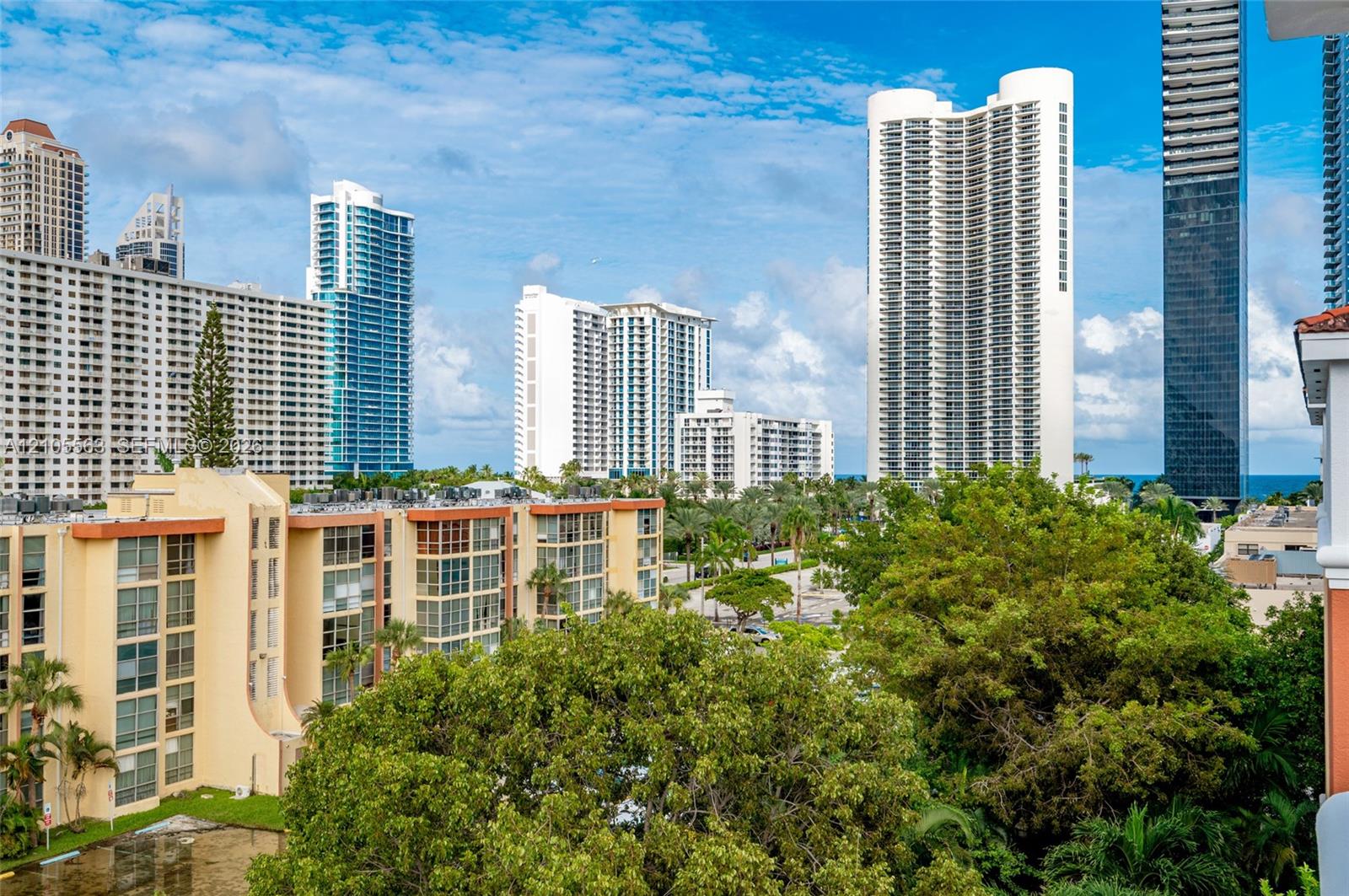 Elevated urban and coastal scenery featuring multiple high-rise buildings and mature tropical landscaping