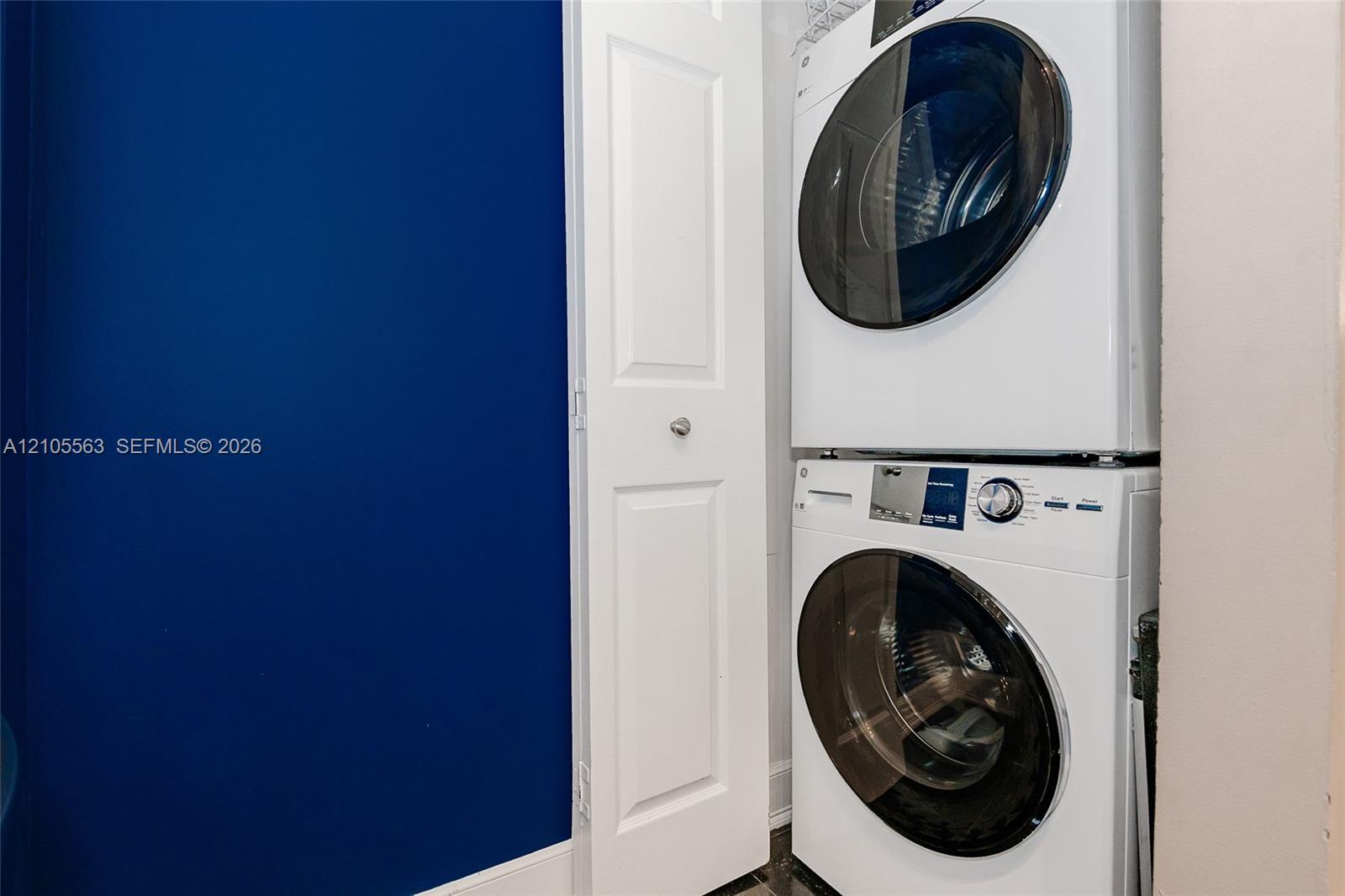 Stacked laundry appliances within a dedicated utility area
