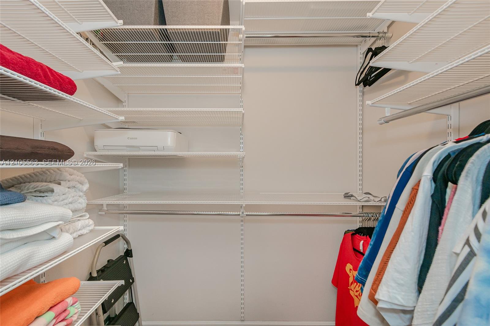 Built-in wire shelving system with multiple storage levels and hanging rods