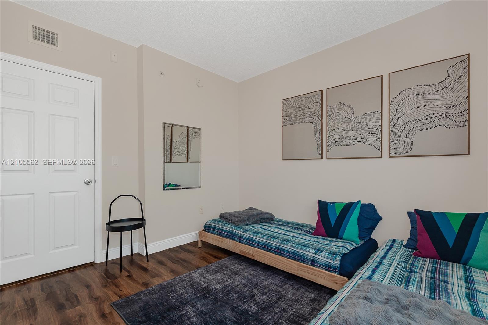 Hardwood-look flooring with light-toned walls and a white paneled door