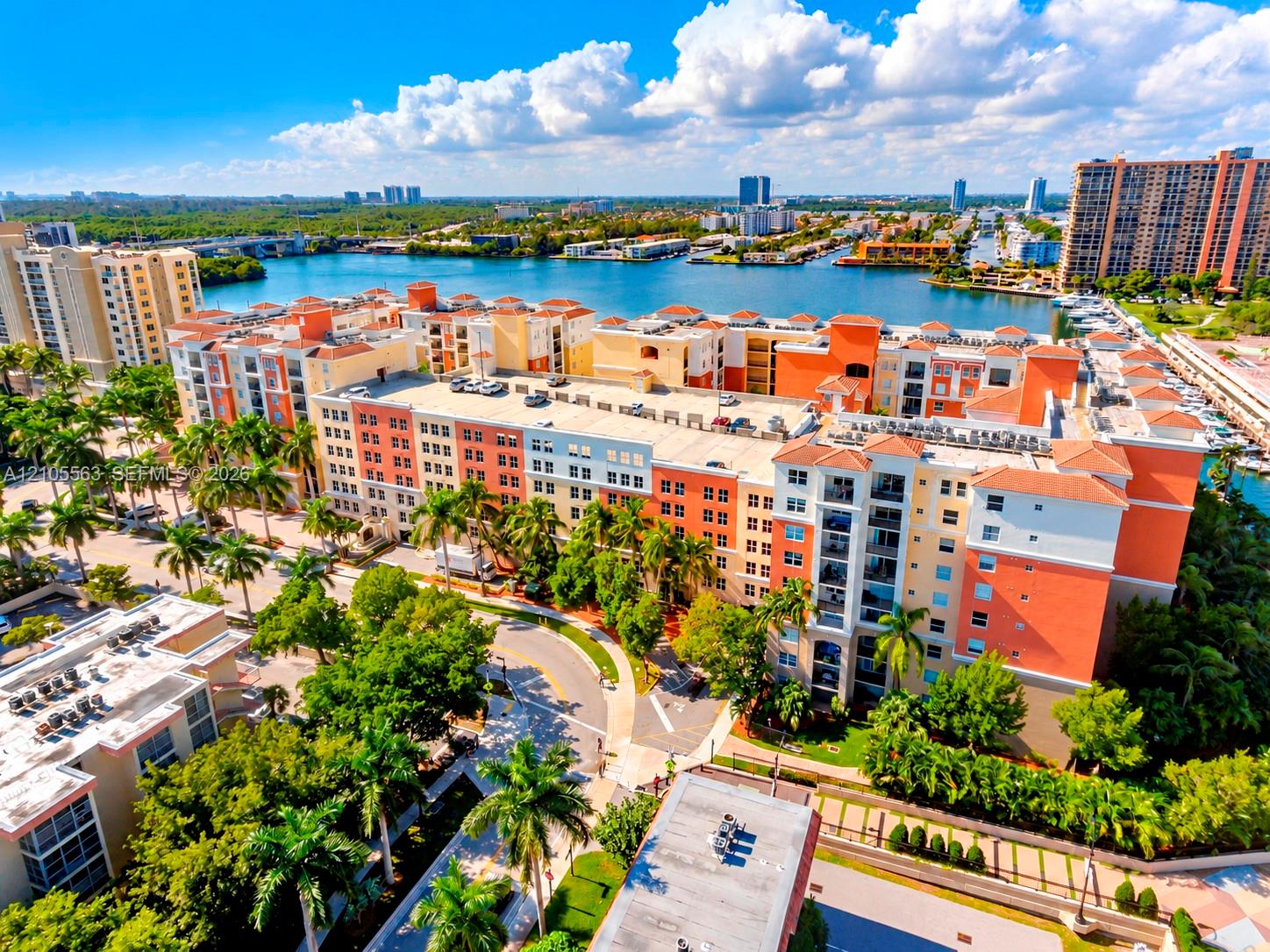 Multi-story residential complex with Mediterranean-style architecture, featuring tiled roofs and private balconies