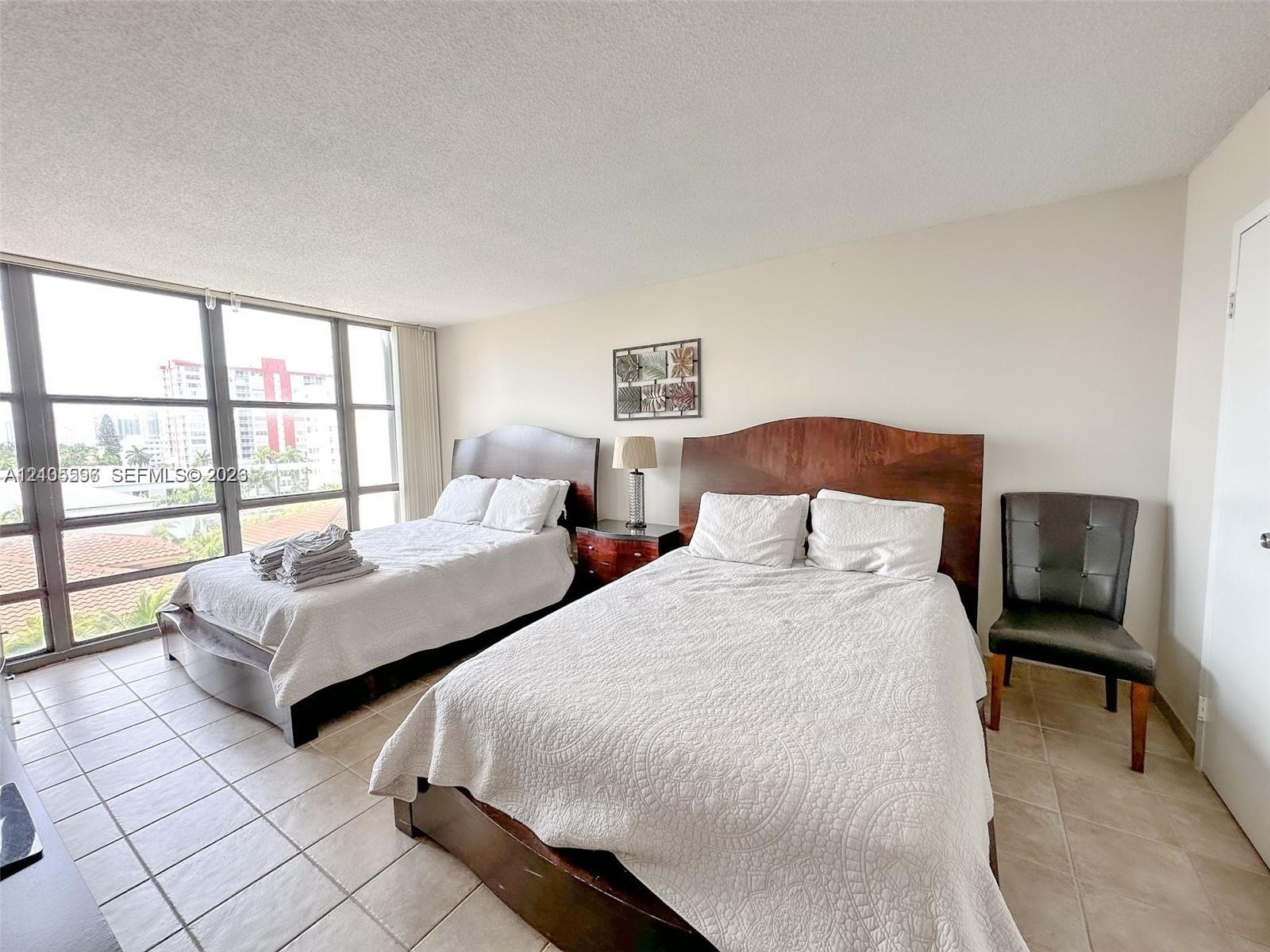 Floor-to-ceiling windows with grid-pattern frames and neutral tile flooring
