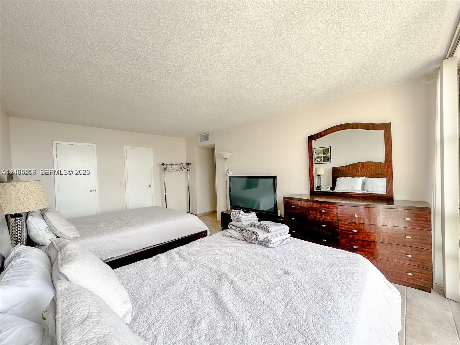Neutral-toned interior space featuring light-colored flooring, dual interior doors, and a full-height window