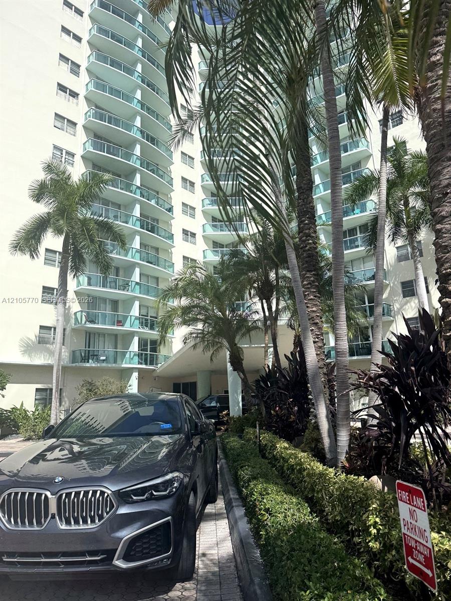 Multi-story building featuring numerous private balconies with clear railings