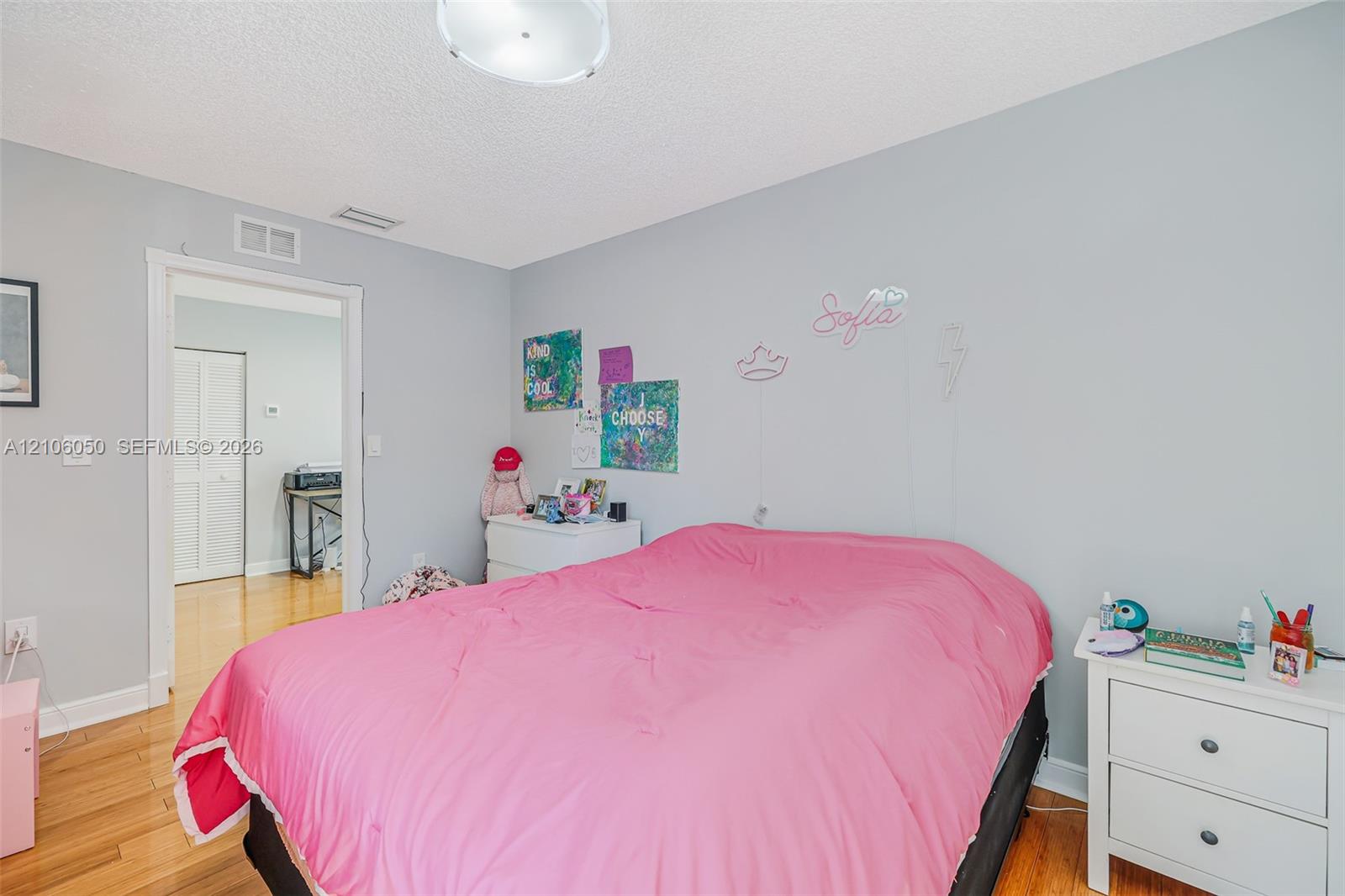 Room featuring wood-finish flooring, a neutral-toned wall finish, and a ceiling-mounted light fixture