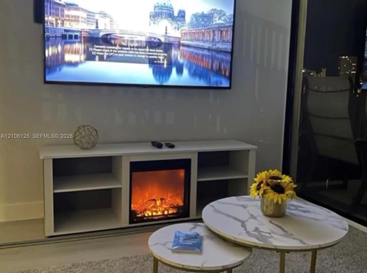 Built-in media console featuring an integrated electric fireplace and open shelving