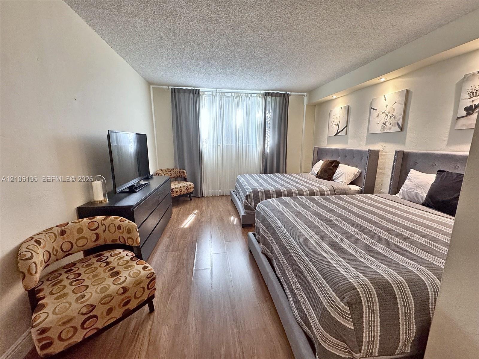 Wood-finish flooring, recessed ceiling lighting, and wall-to-wall window treatments