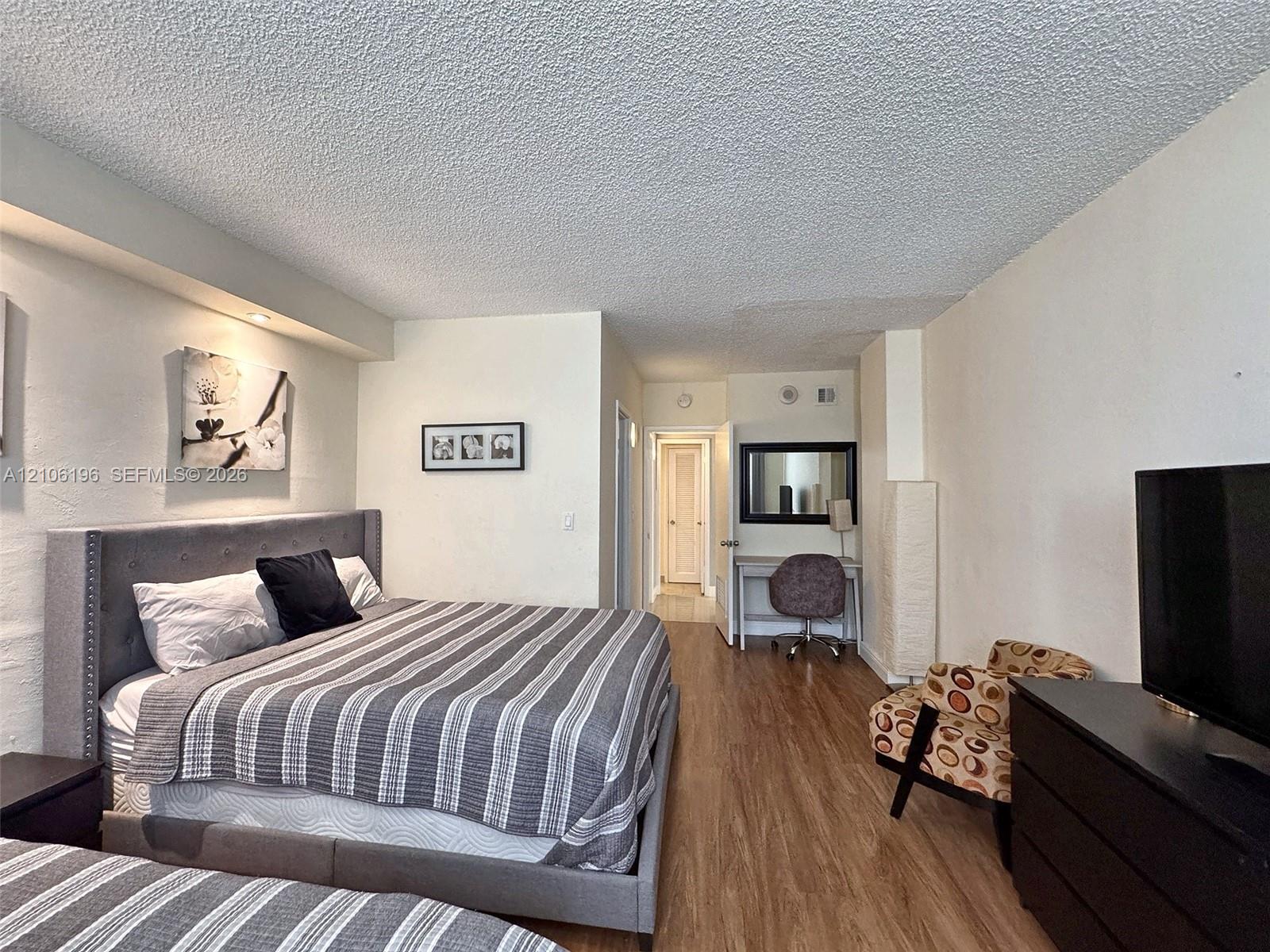 Wood-finish flooring, recessed ceiling lighting, and textured ceiling finish