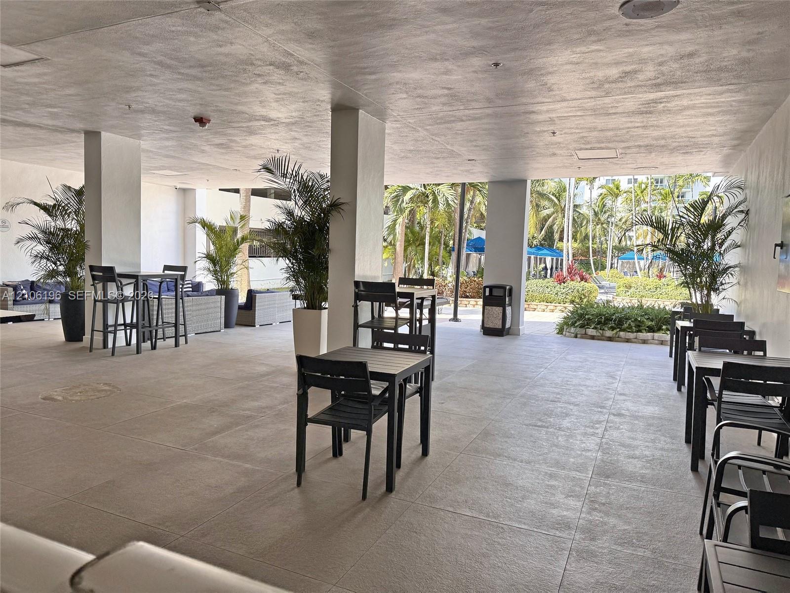 Covered outdoor terrace featuring large-format tile flooring and structural support columns