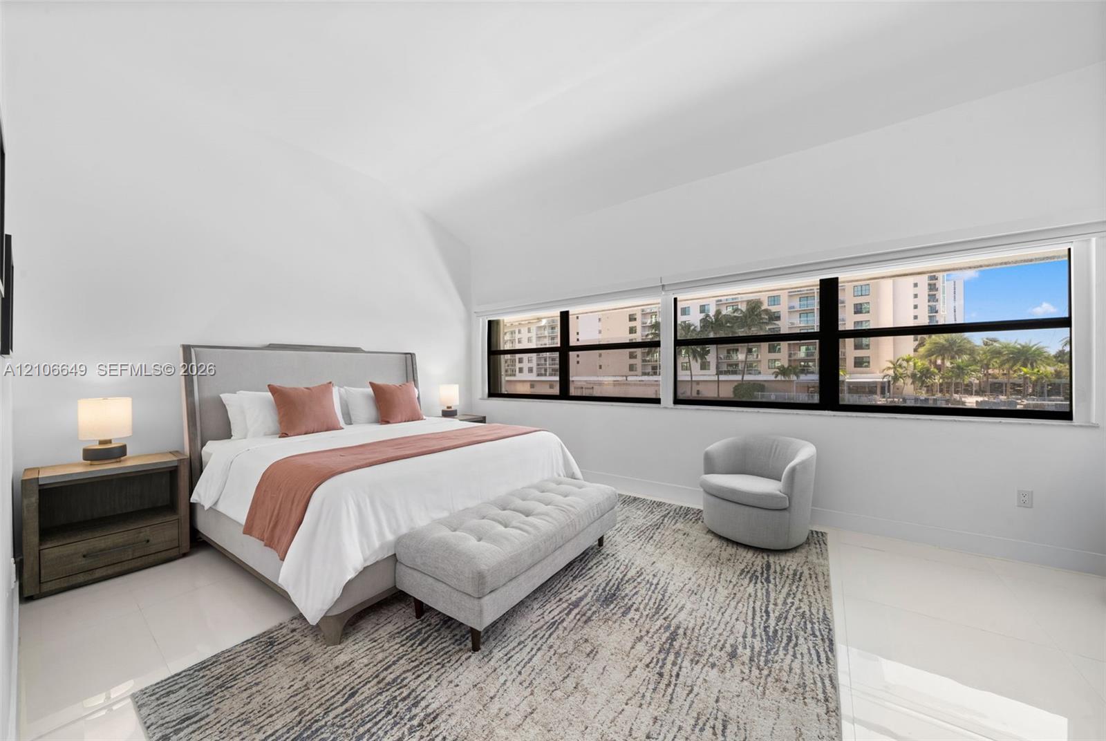 Spacious interior with high vaulted ceilings, large expansive window configuration, and polished tile flooring