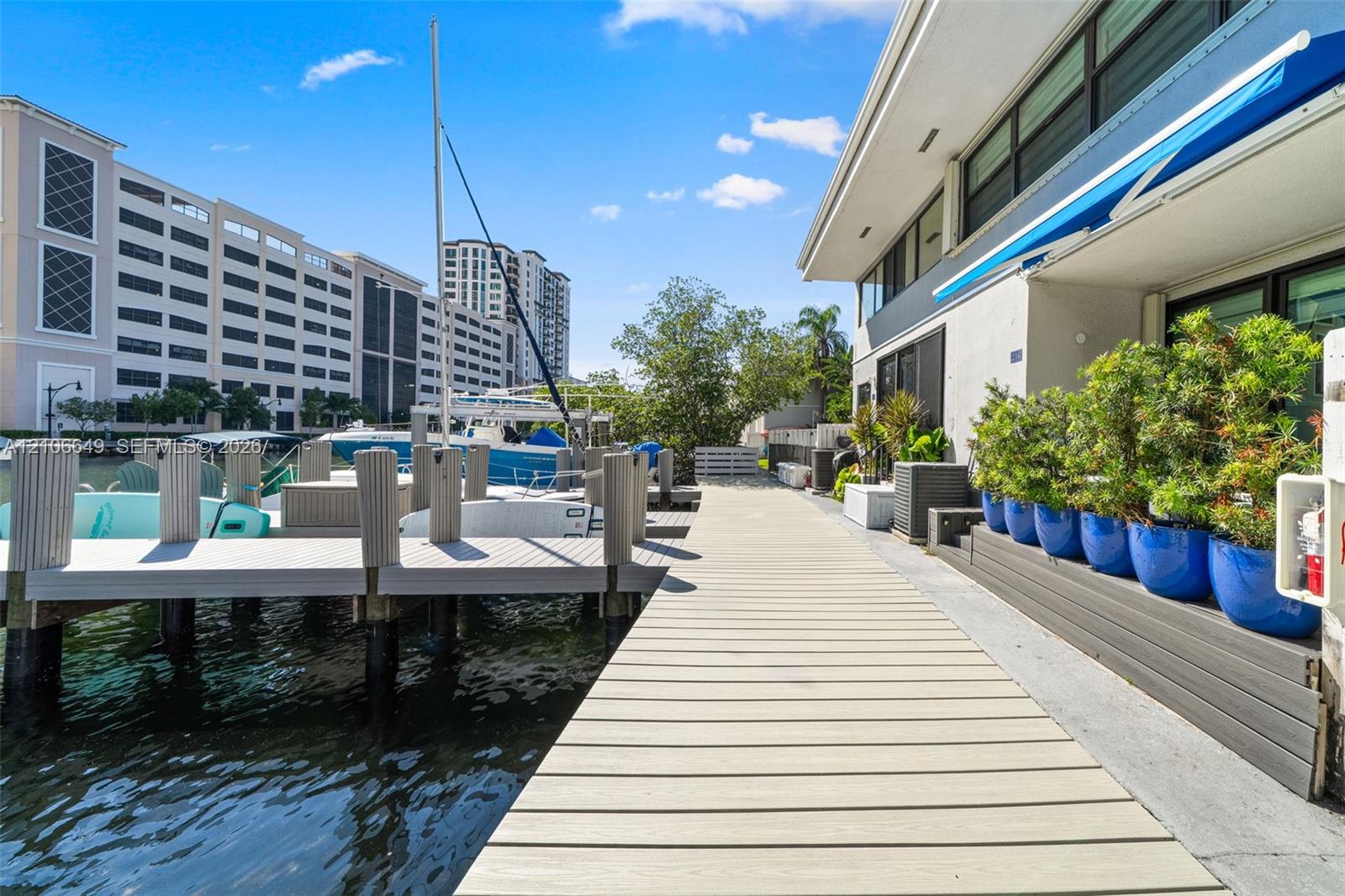 Waterfront boardwalk featuring a private boat slip, concrete bulkhead, and industrial-grade pilings