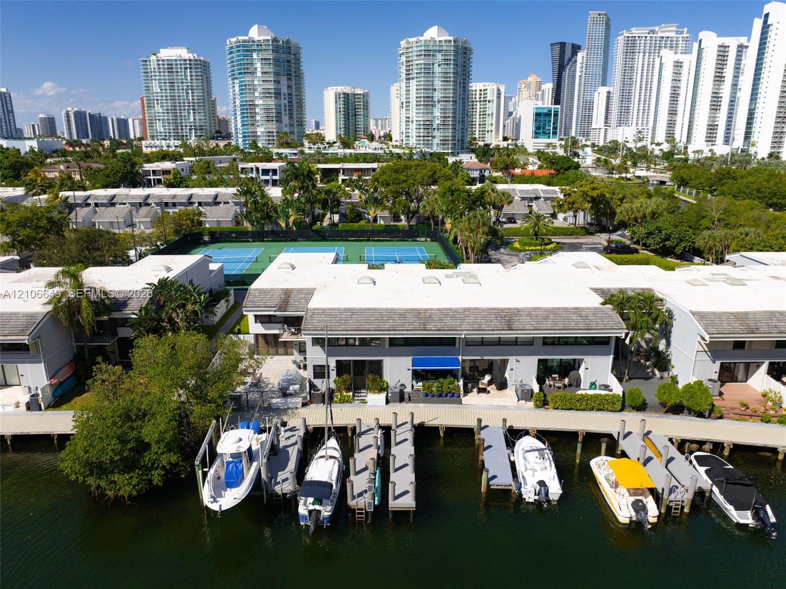 Waterfront terrace featuring composite decking, an retractable fabric awning, and direct access to a private boat dock