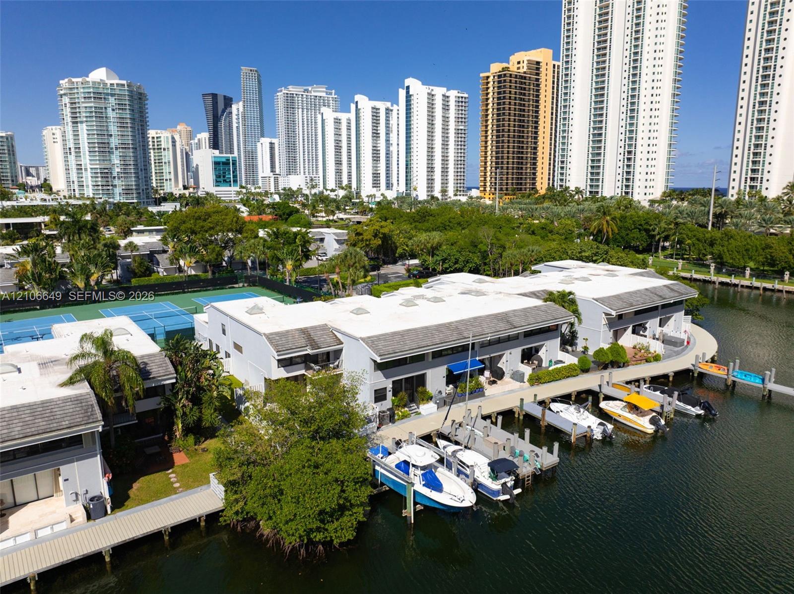 Waterfront property featuring a private composite dock, direct water access, and exterior stairs with integrated landscaping