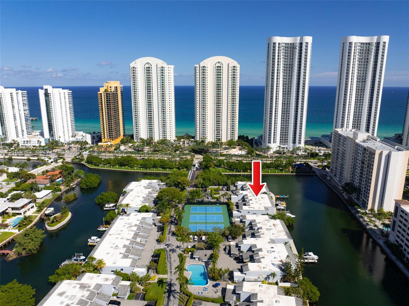 Waterfront property featuring a private deep-water dock, integrated boat slips, paved pathways, and tennis courts