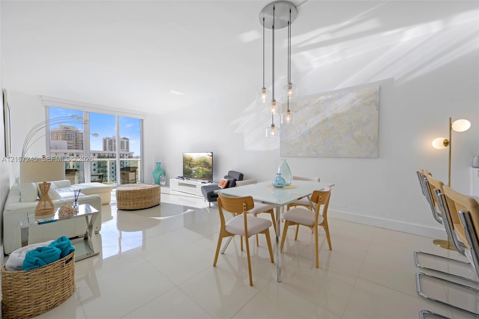 Living area featuring polished tile flooring, floor-to-ceiling glass windows, and a multi-pendant light fixture