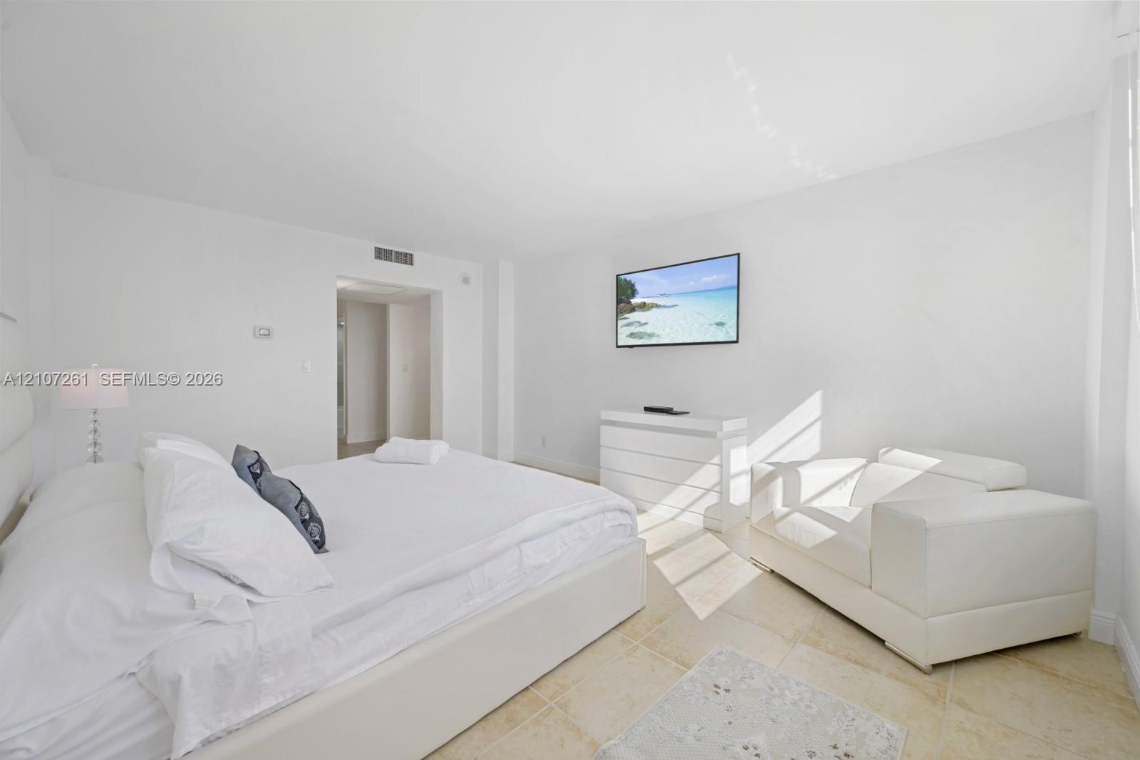 Neutral-toned room with natural stone flooring and recessed ceiling lighting