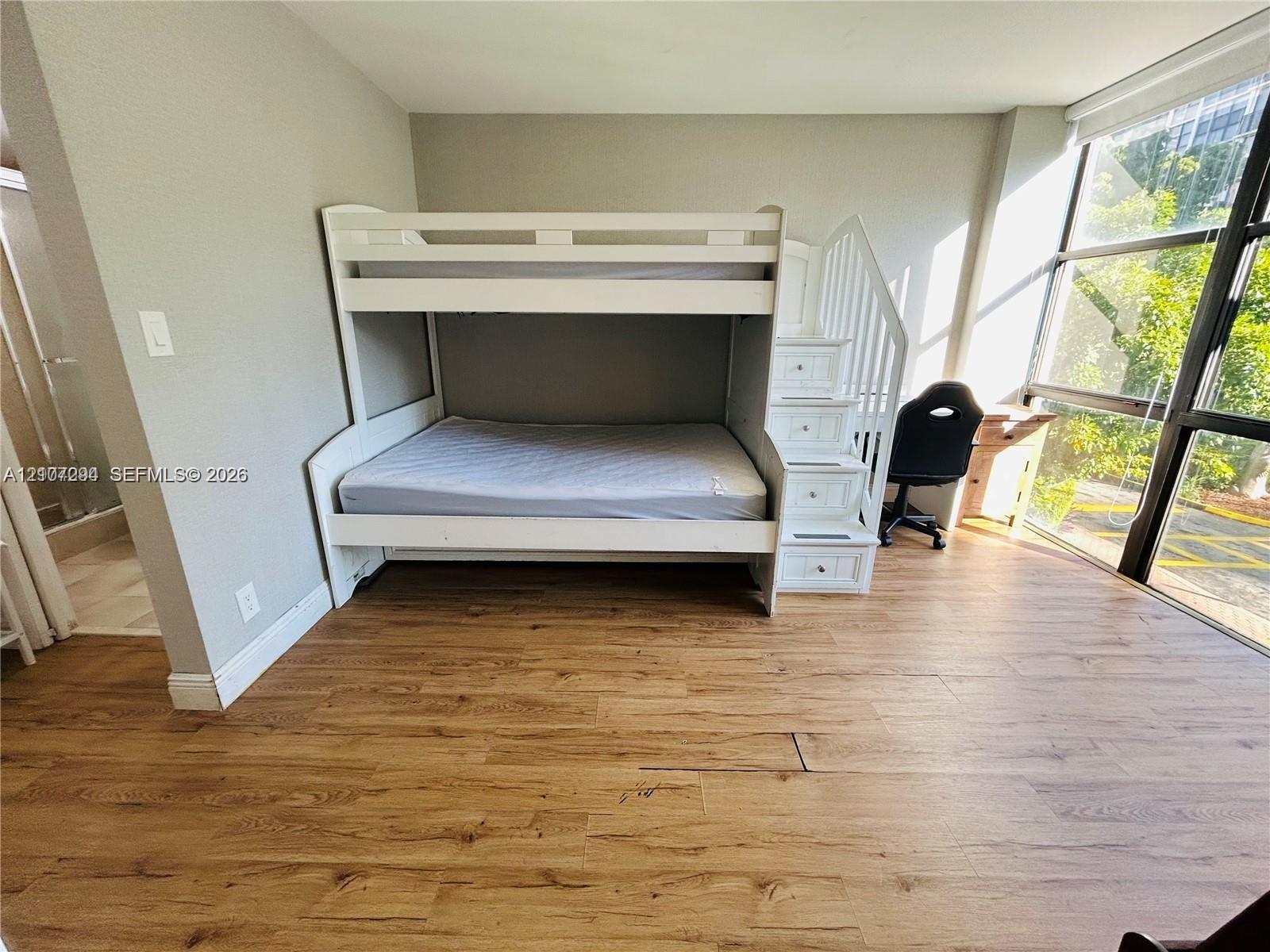 Floor-to-ceiling windows with black metal framing and wood-finish flooring