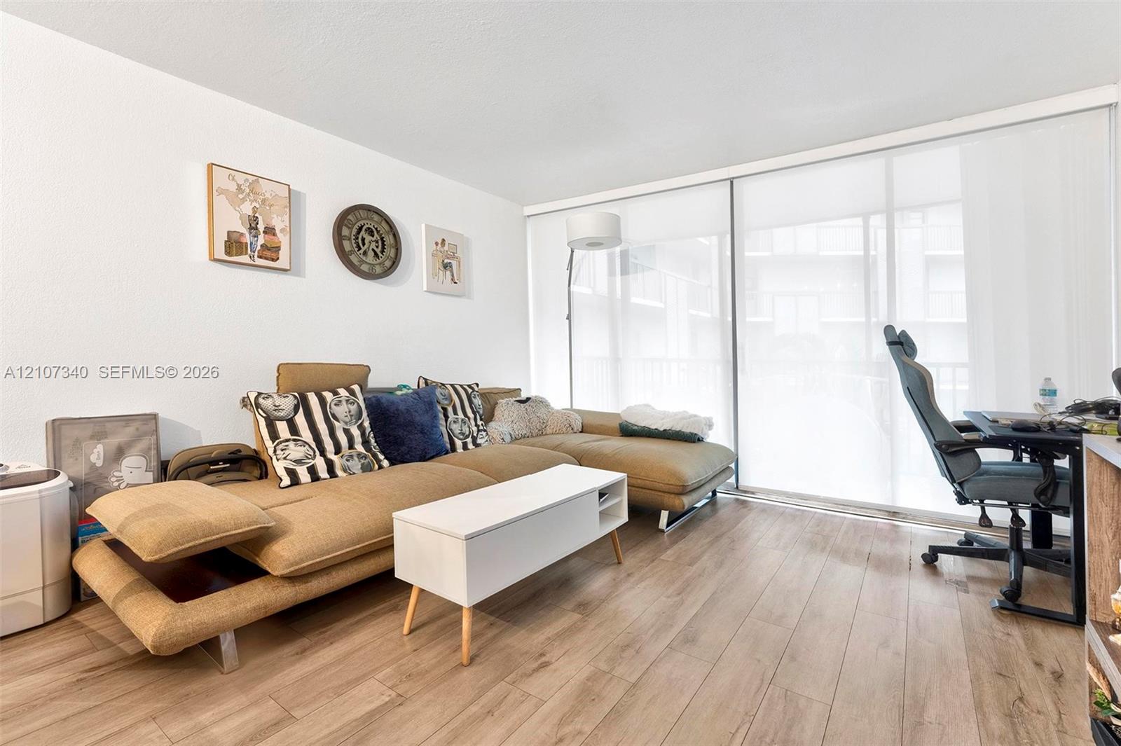 Wood-finish flooring and floor-to-ceiling sliding glass doors with integrated roller shades