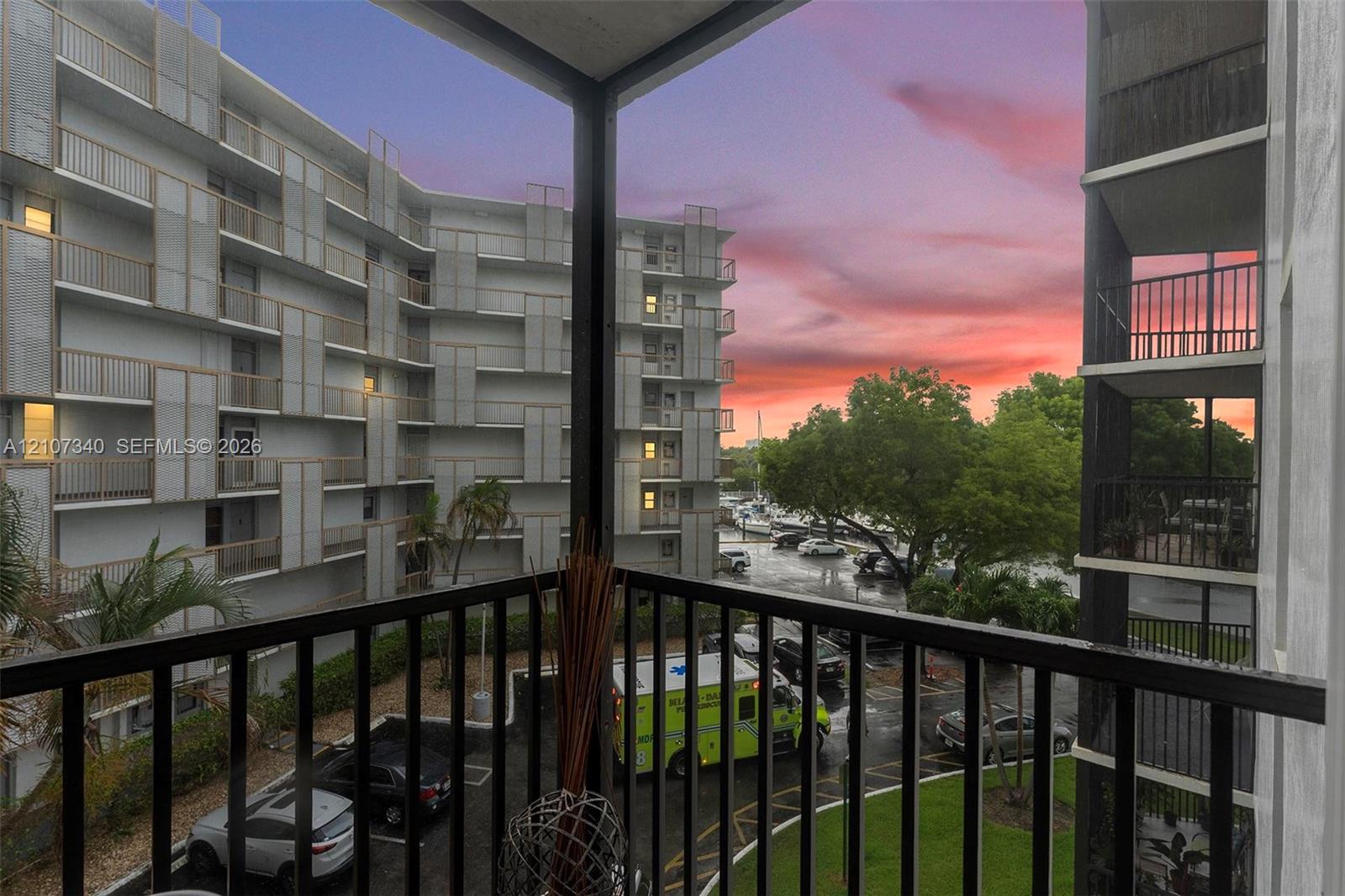 Covered private balcony featuring black metal railings and overhead lighting