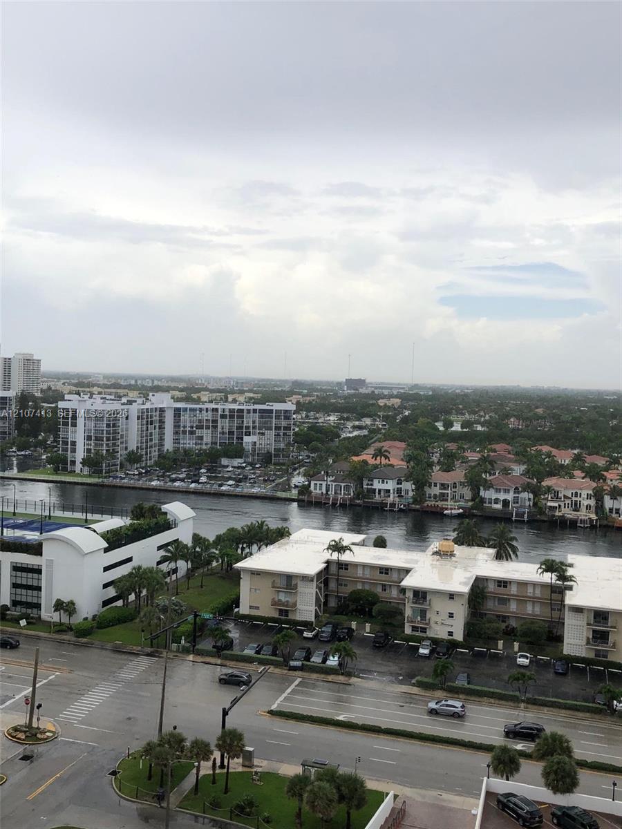 Elevated perspective featuring extensive water frontage, palm-lined residential streets, and horizon-spanning cityscape