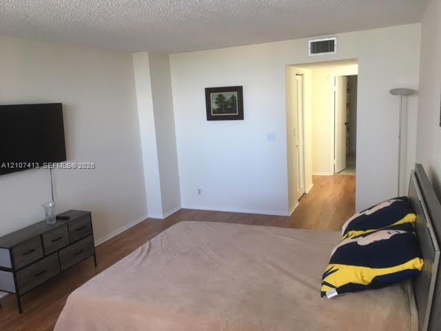 Room featuring wood-finish flooring and neutral wall paint