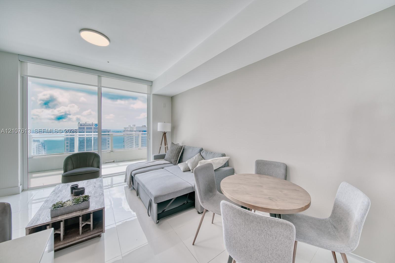Floor-to-ceiling windows, porcelain tile flooring, recessed LED ceiling lighting, and private balcony access