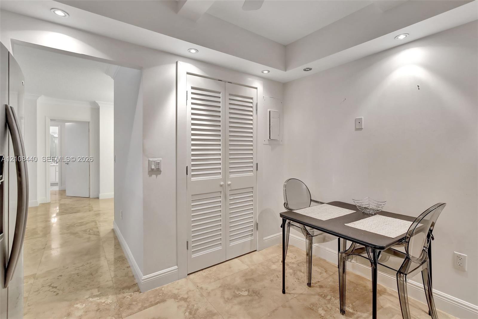Interior space featuring recessed lighting, polished stone flooring, and double louvered-panel doors