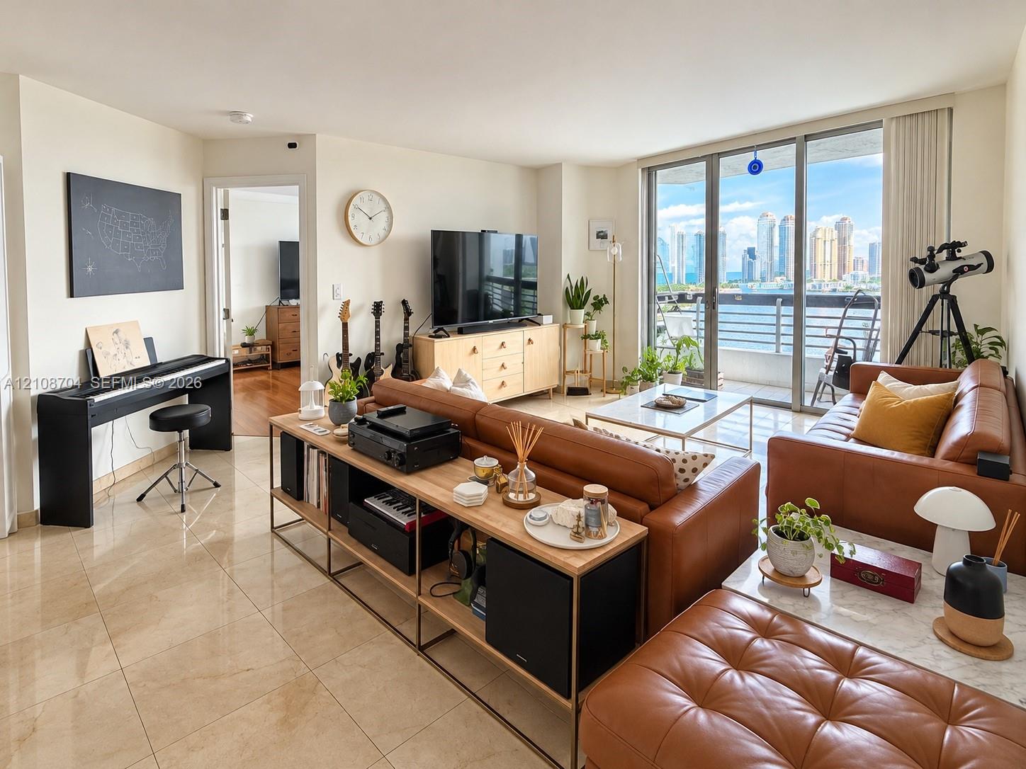 Open-concept living space featuring polished tile flooring, floor-to-ceiling glass sliding doors, and a private balcony