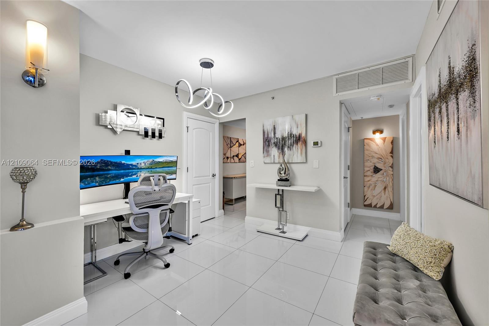 High-gloss tile flooring, charcoal accent wall, integrated white headboard with built-in side tables, and modern multi-bulb flush-mount ceiling lighting
