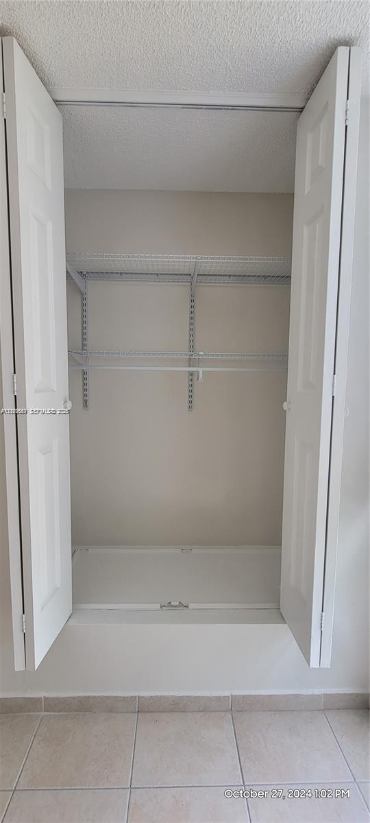Storage closet featuring dual bifold doors and white wire shelving