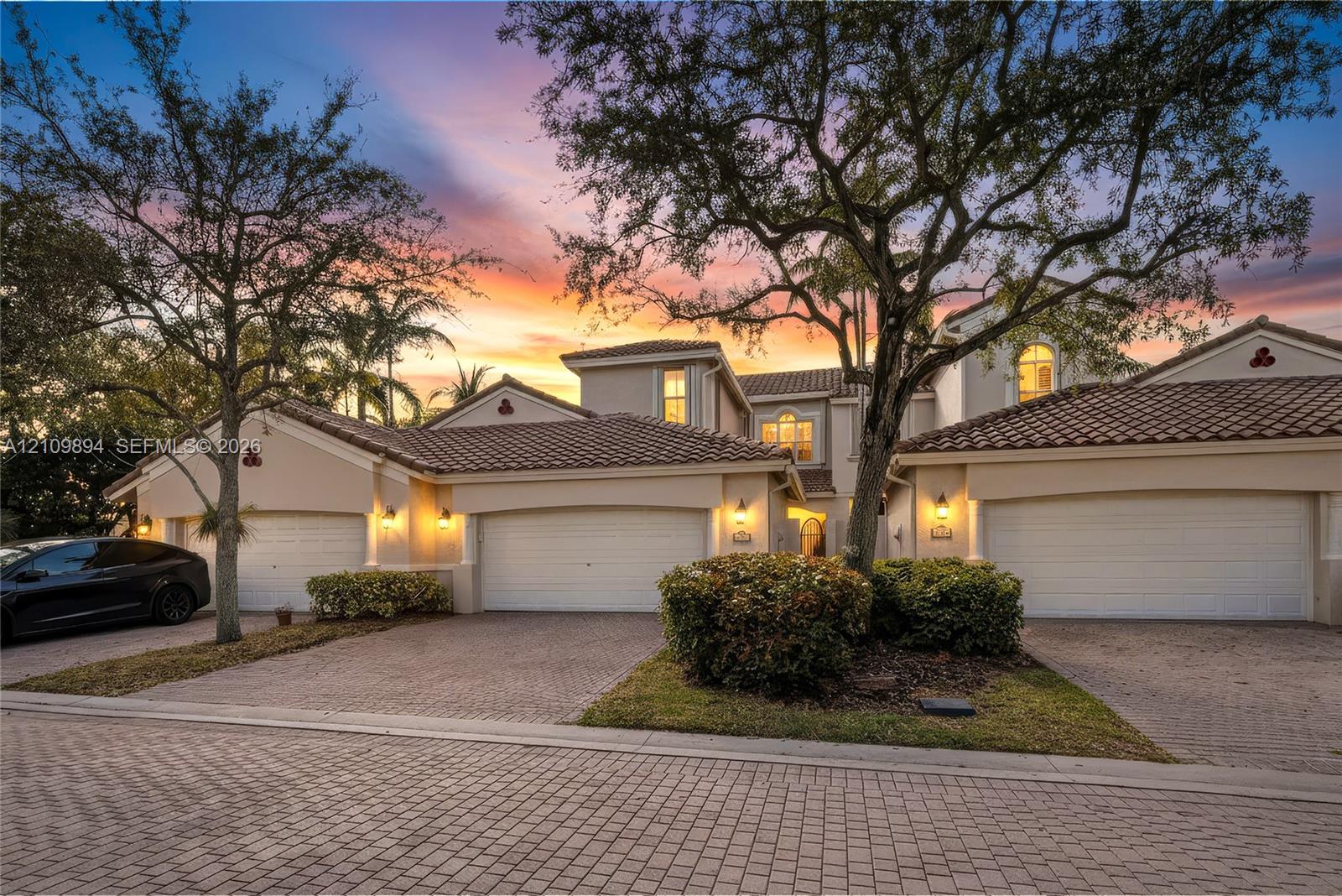 Private outdoor area featuring synthetic turf, perimeter privacy screening, mature landscape hedging, and decorative stone borders